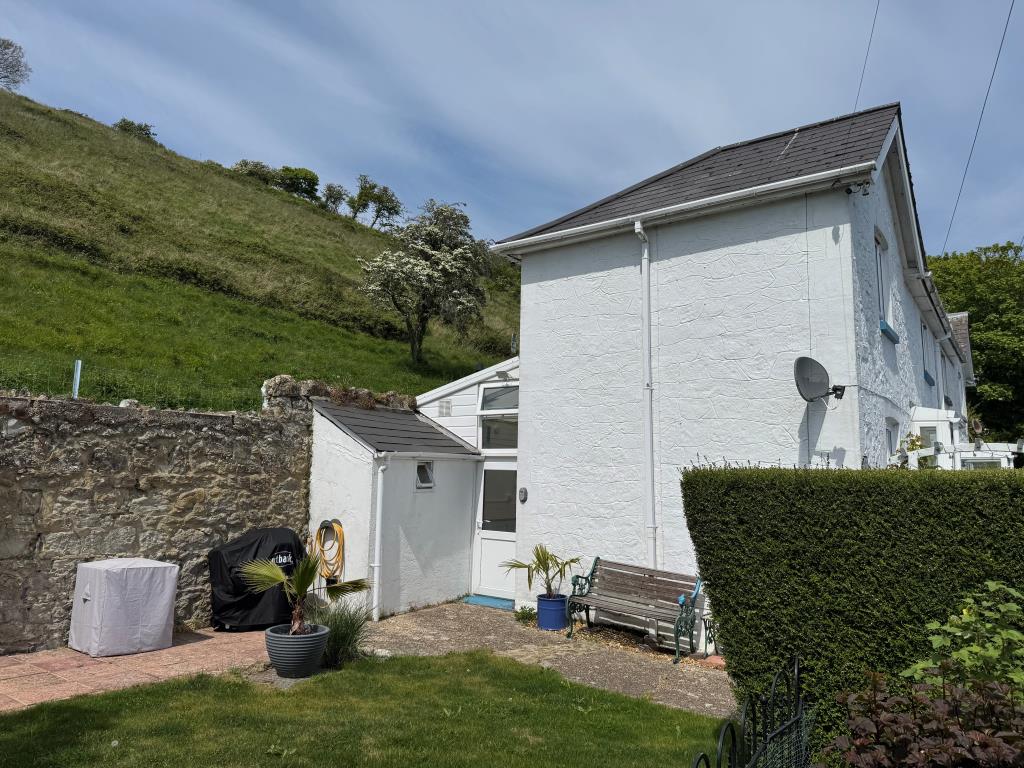 Lot: 142 - COTTAGE WITH SEA VIEWS FOR INVESTMENT OR OCCUPATION - A Side View of the Cottage and St Boniface Down Behind